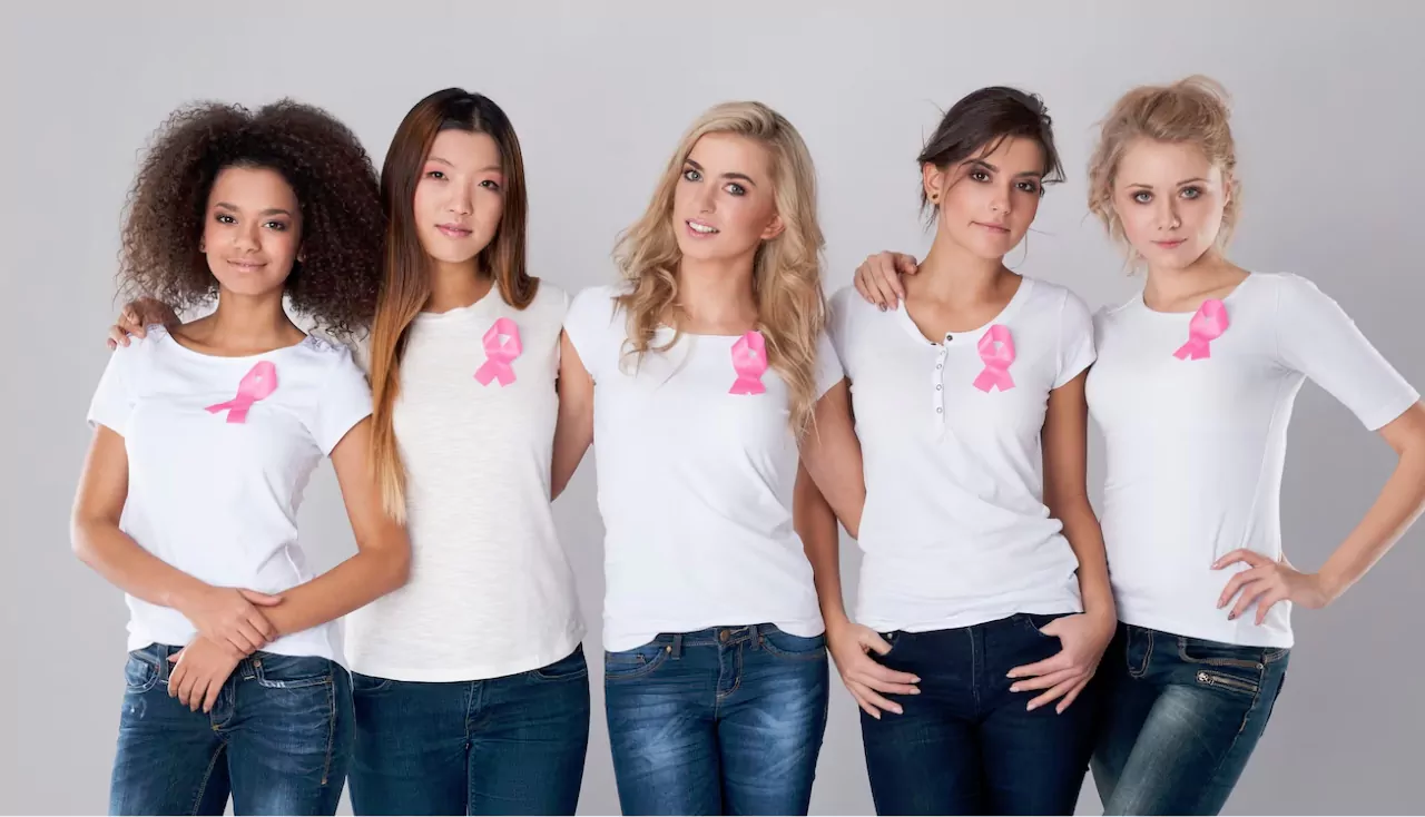 Women healthcare, breast cancer, medicine concept. Portrait of five young girl friends in white tshirts with pink breast cancer awareness ribbon on chest, isolated on white background, smiling, bonding