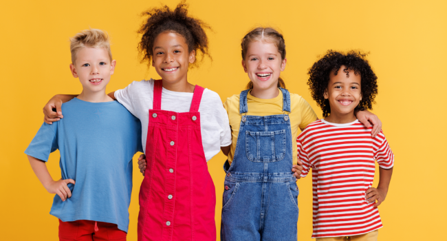 Group of cheerful happy multinational children on yellow background