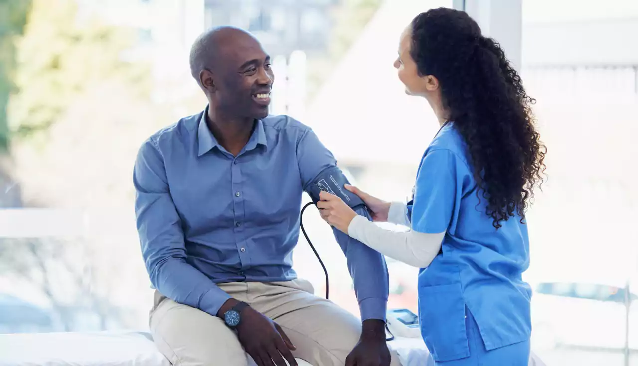 Black man, doctor and blood pressure healthcare in hospital for health insurance consultation. Patient and professional nurse woman talking about hypertension, wellness and advice for healthy life