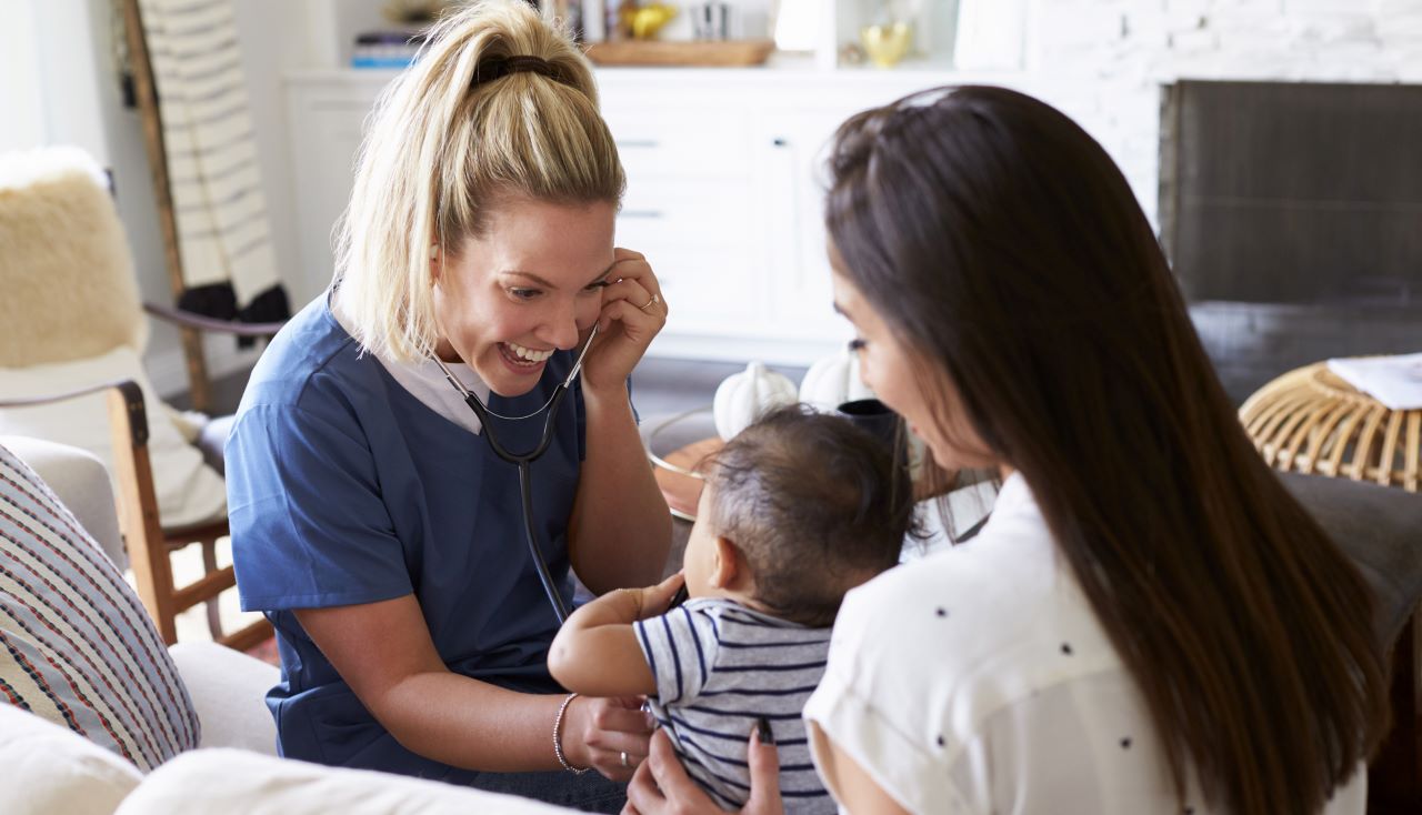 nurse with stethoscope with mother and child in home