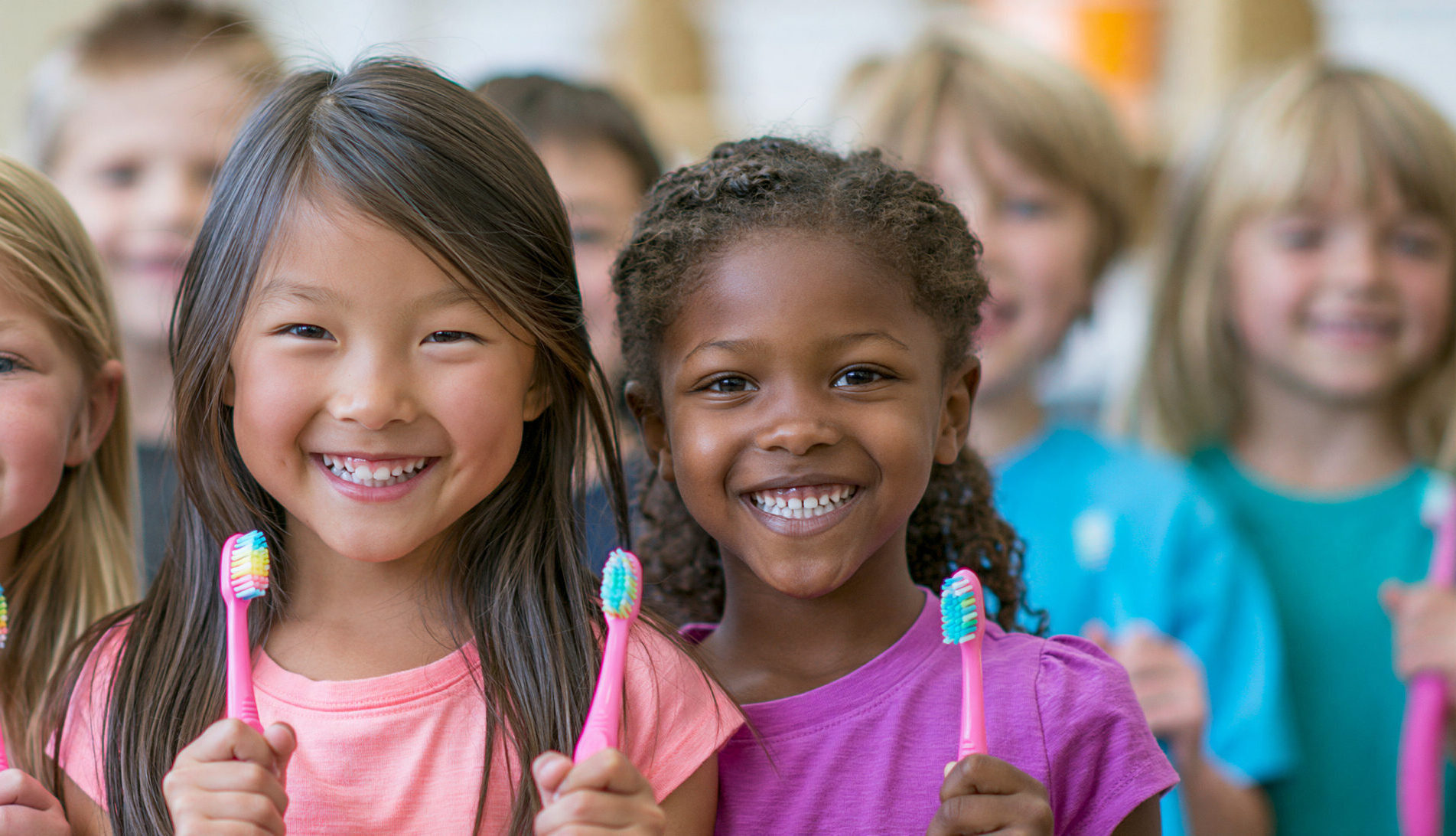 group of children holding toothbrushes