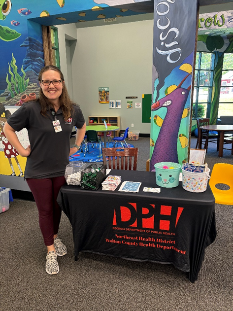 Health Educator at a school event, providing table of educational information.